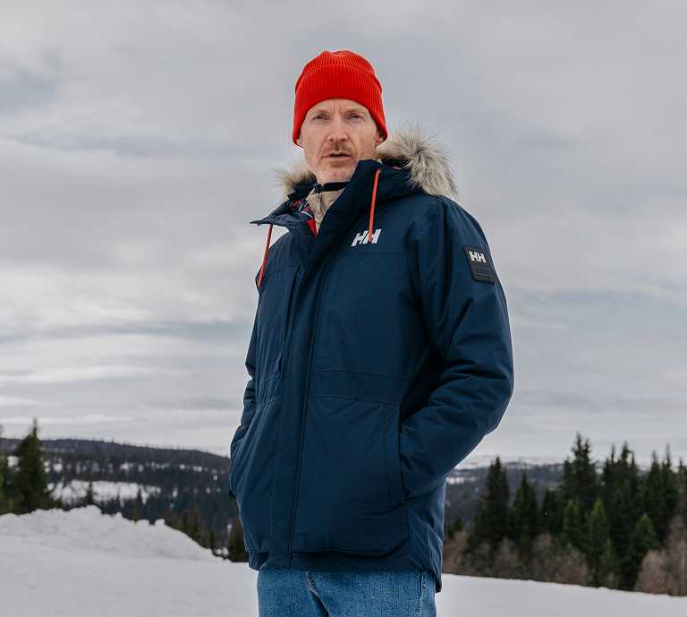 man walking in street in green jacket