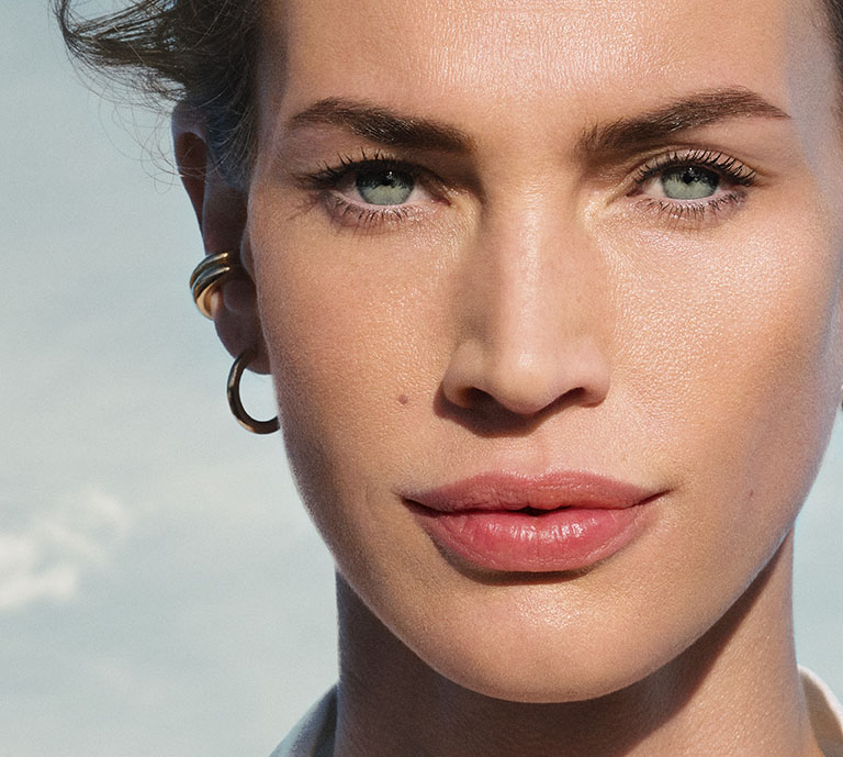 Image of model with glowing skin against clouds