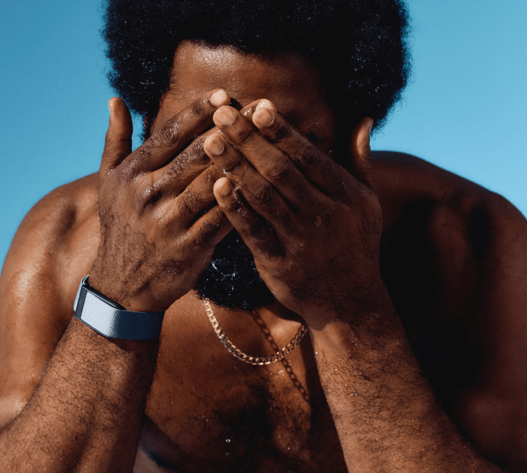 Man rinsing face wearing WHOOP