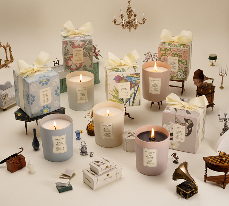 An image showing the Jo Malone, Little Greene candles lit amongst a table scape.