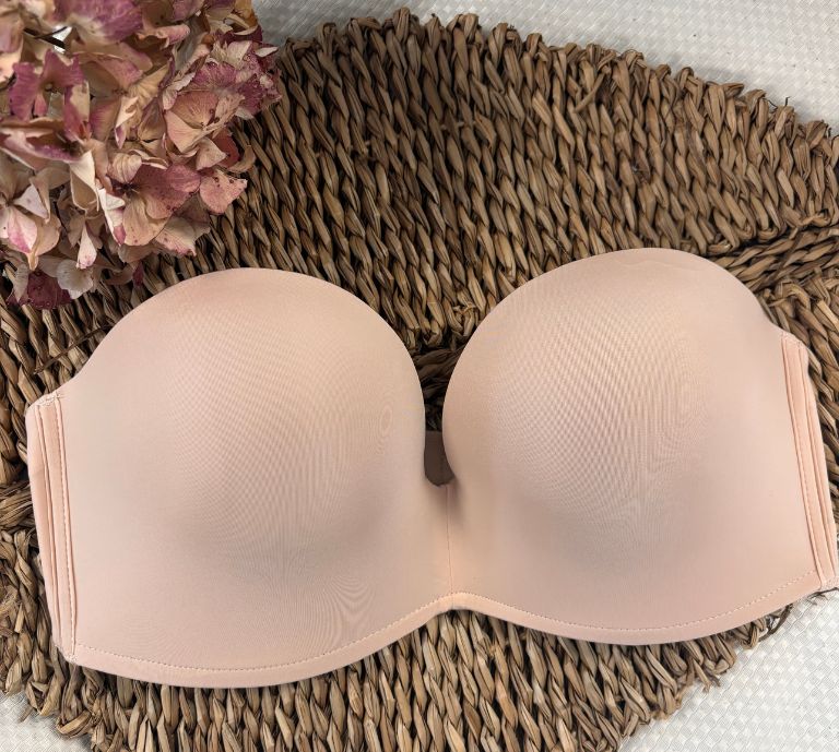 Our iconic strapless bra in black colour surrounded by autumn leaves