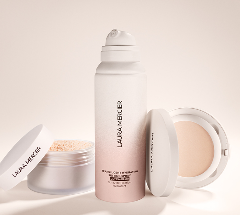 Banner advertisement for Laura Mercier Translucent Setting Spray Ultra Blur with Translucent Loose Setting Powder Ultra Blur and Translucent Pressed Setting Powder Ultra Blur to the left and right.
