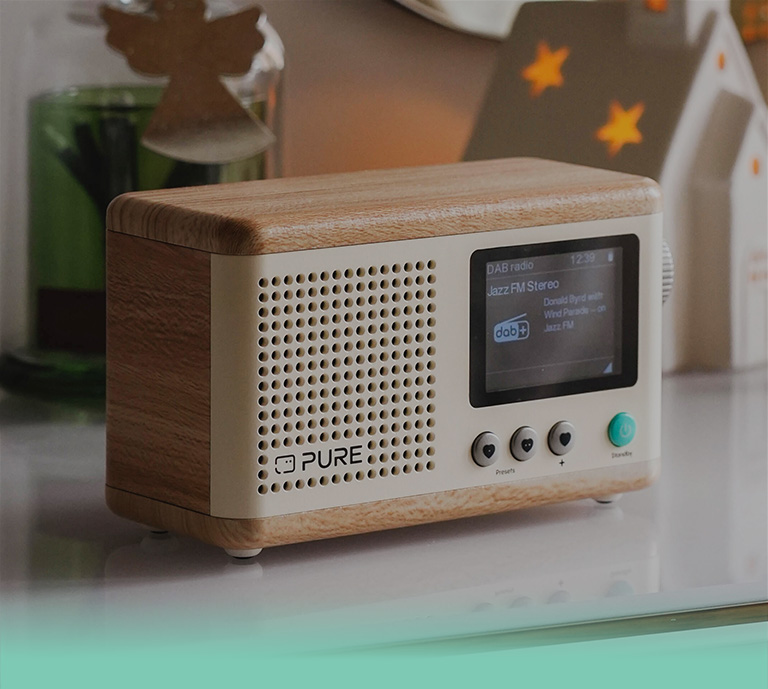 Pure Classic compact stereo mini system with matching speakers in Oak and cotton white finish.  Featuring DAB+, FM radio and Bluetooth connectivity, displayed in a stylish home setting.