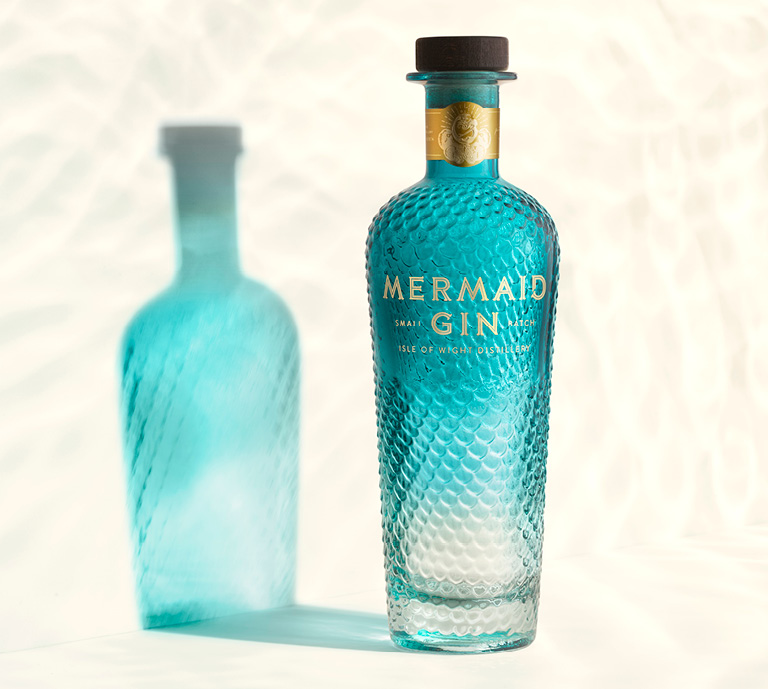 Mermaid Blue Gin bottle shown with embossed glass design in shades of deep blue.