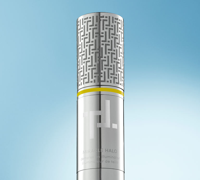 An image of Trinny London's Miracle Halo complexion illuminator. The silver primary packaging is set against a list blue background.