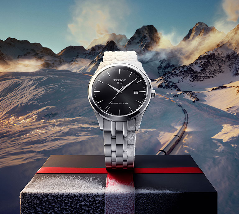 Tissot Classic Dream with a black dial positioned on a gift box with a mountain landscape in the background