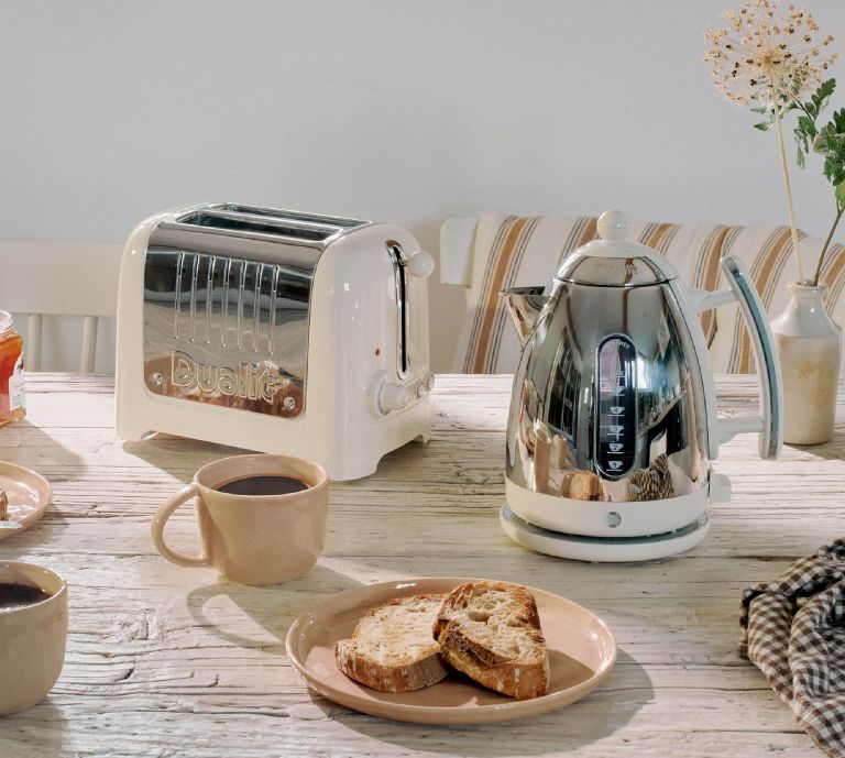 Dualit Canvas White 2 Slice Toaster and Kettle on a kitchen table with toast and coffee
