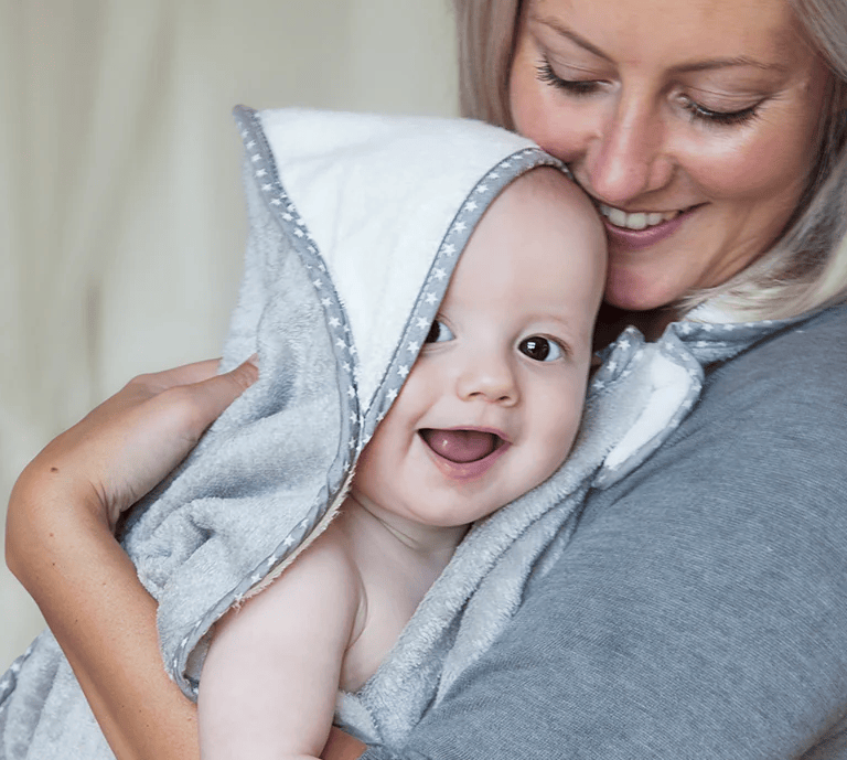 Image of a mother with her baby in the Cuddledry blanket with a shop now button